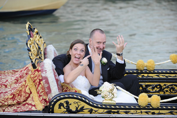 Glückliche Braut und Bräutigam in Gondel auf dem Canal Grande.